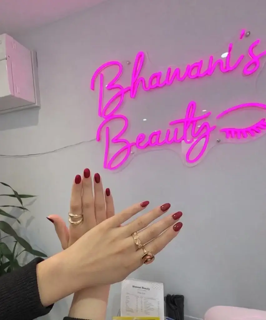 Burgundy manicure beside the Bhawani Beauty salon sign in Guildford