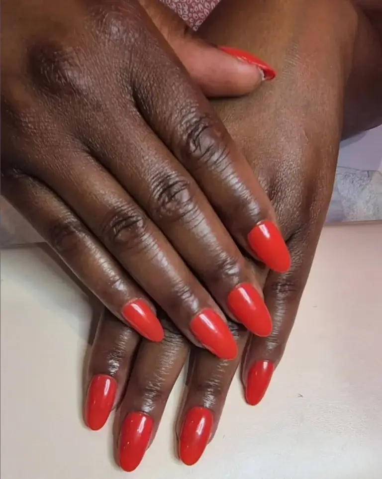 Glossy red almond-shaped nail treatment at Bhawani Beauty Guildford
